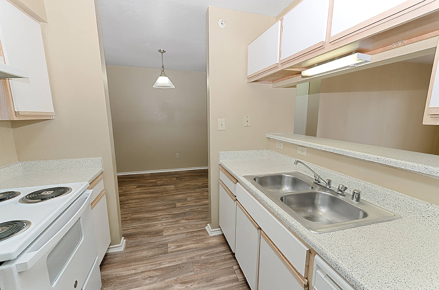 A light kitchen with hardwood floors at the Valley Trails Apartments in Irving, Texas.